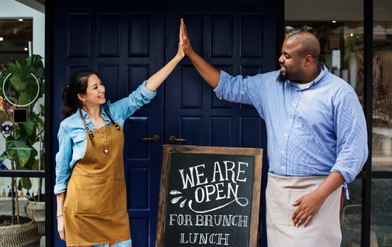Business owners giving each other a high five